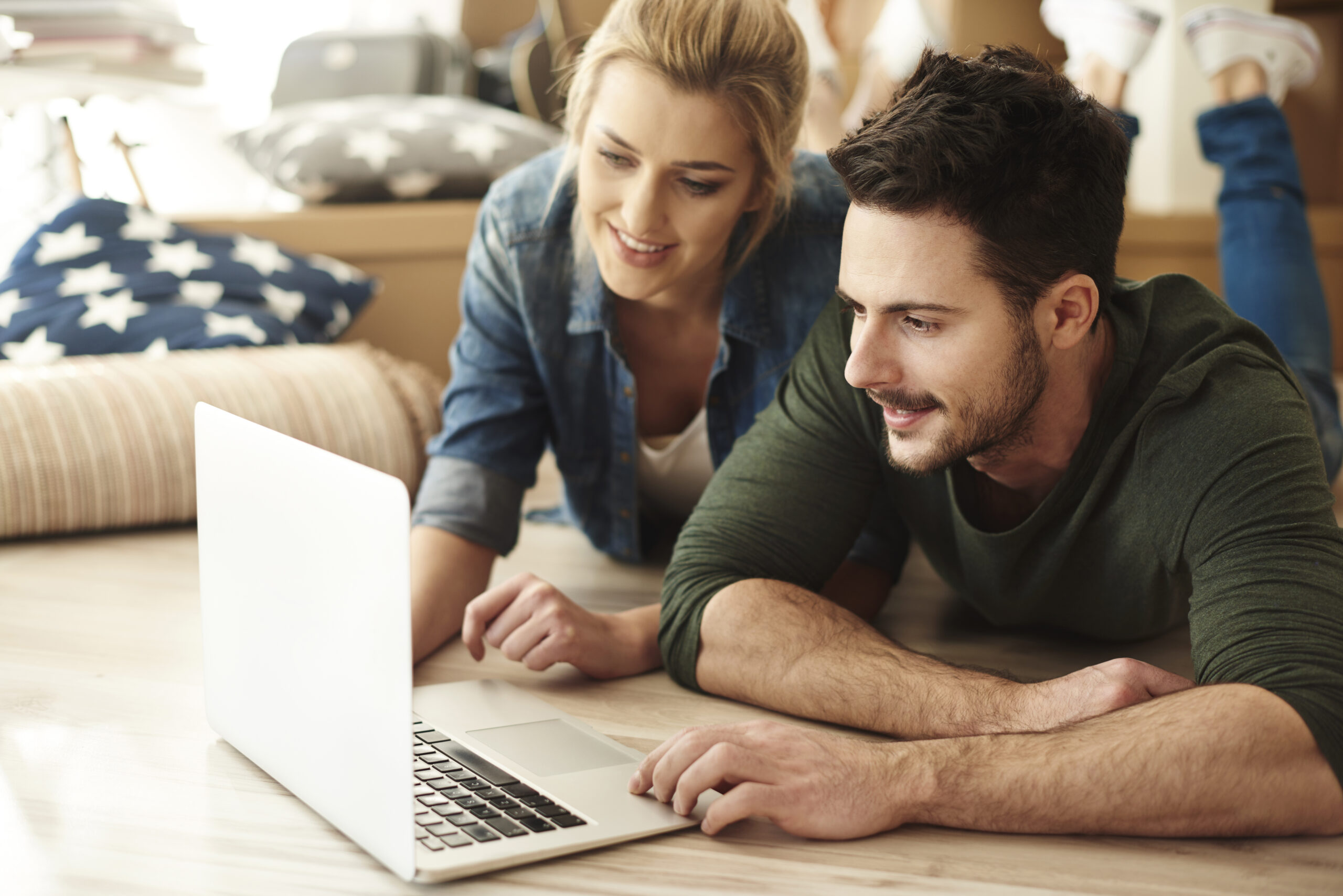 Young couple in new flat using laptop